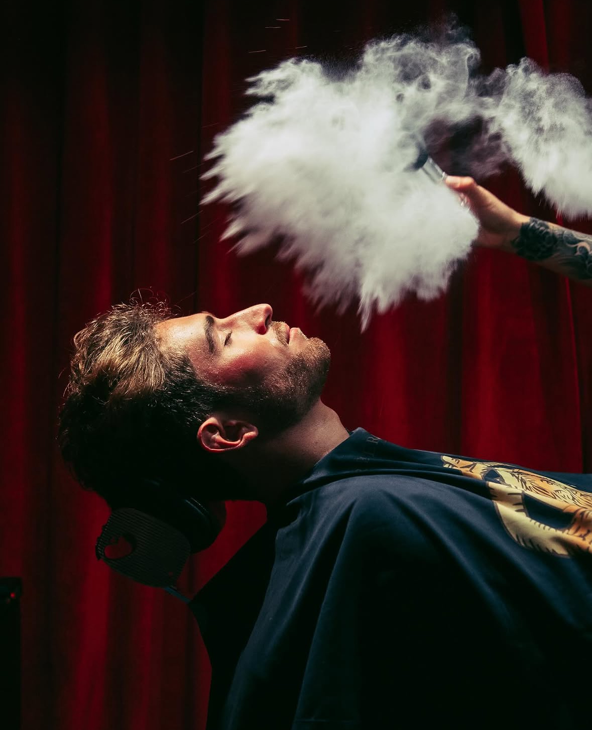Le Barbier des Voyeurs — soin de barbier devant les rideaux rouges